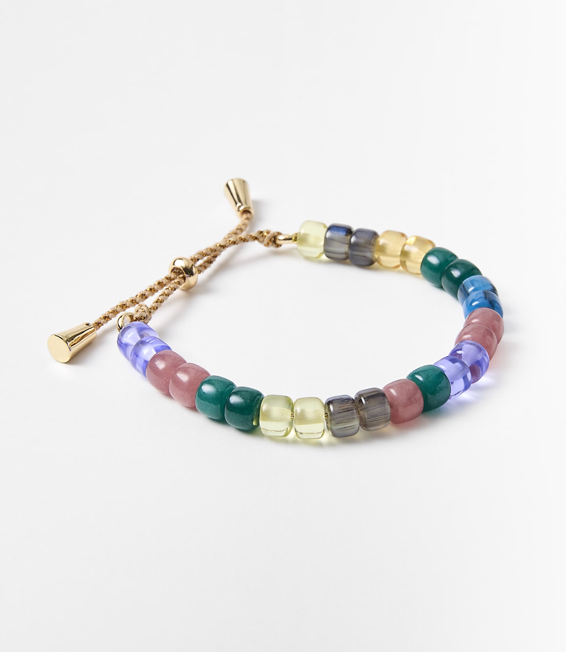 A colorful beaded bracelet with gold accents rests on a plain white background.