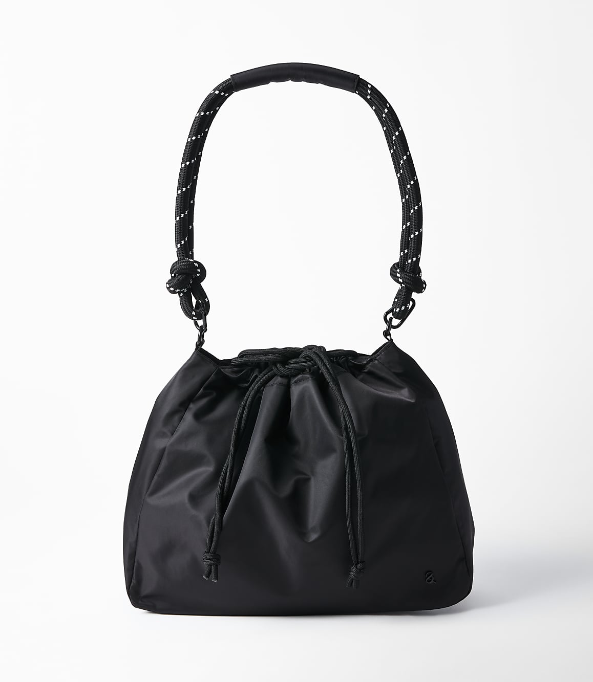 A black drawstring bucket bag with a rope handle hangs against a plain white background.