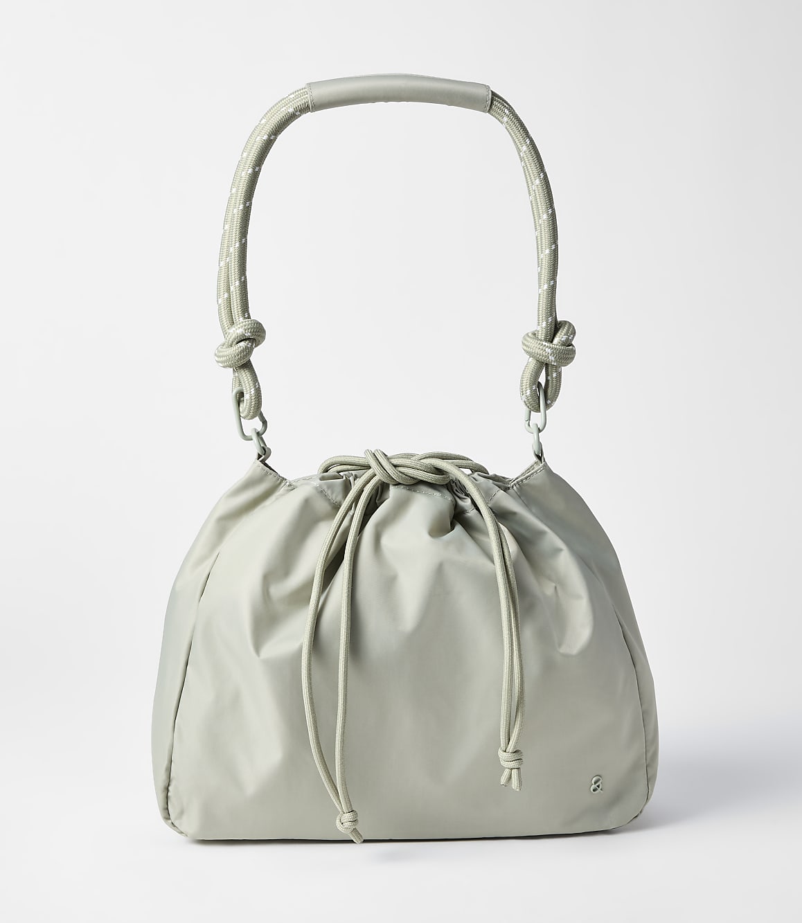 A light gray drawstring bag with a curved handle rests on a plain white background.