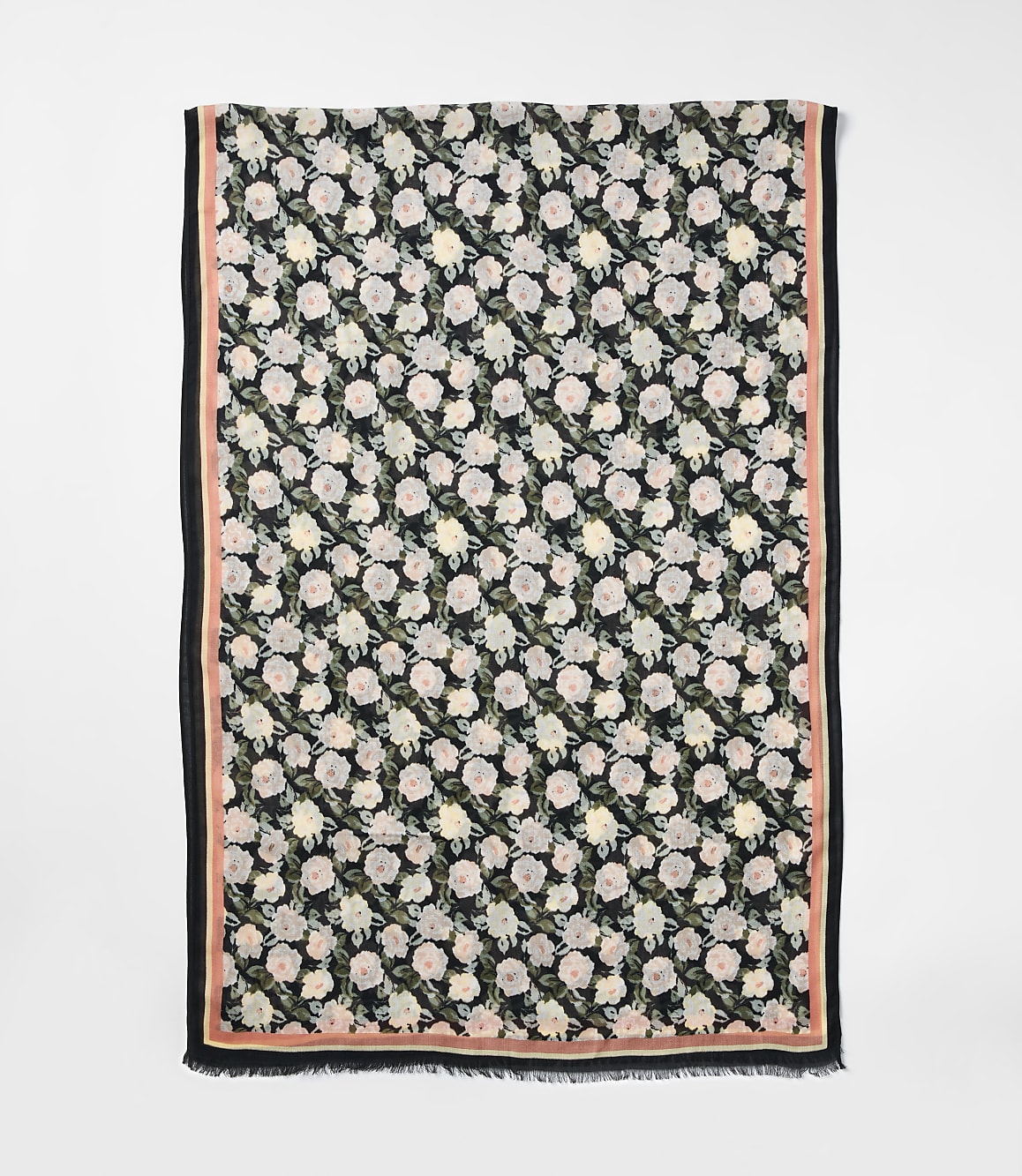 A floral scarf with a black background and pink border is laid out against a plain white background.