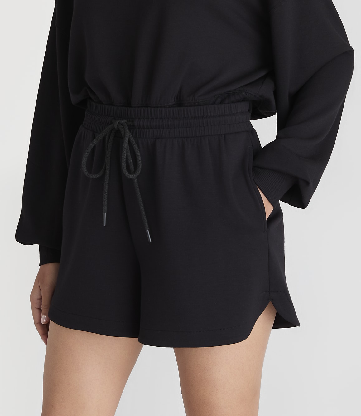Black shorts with a drawstring waist are worn by a person against a plain white background.