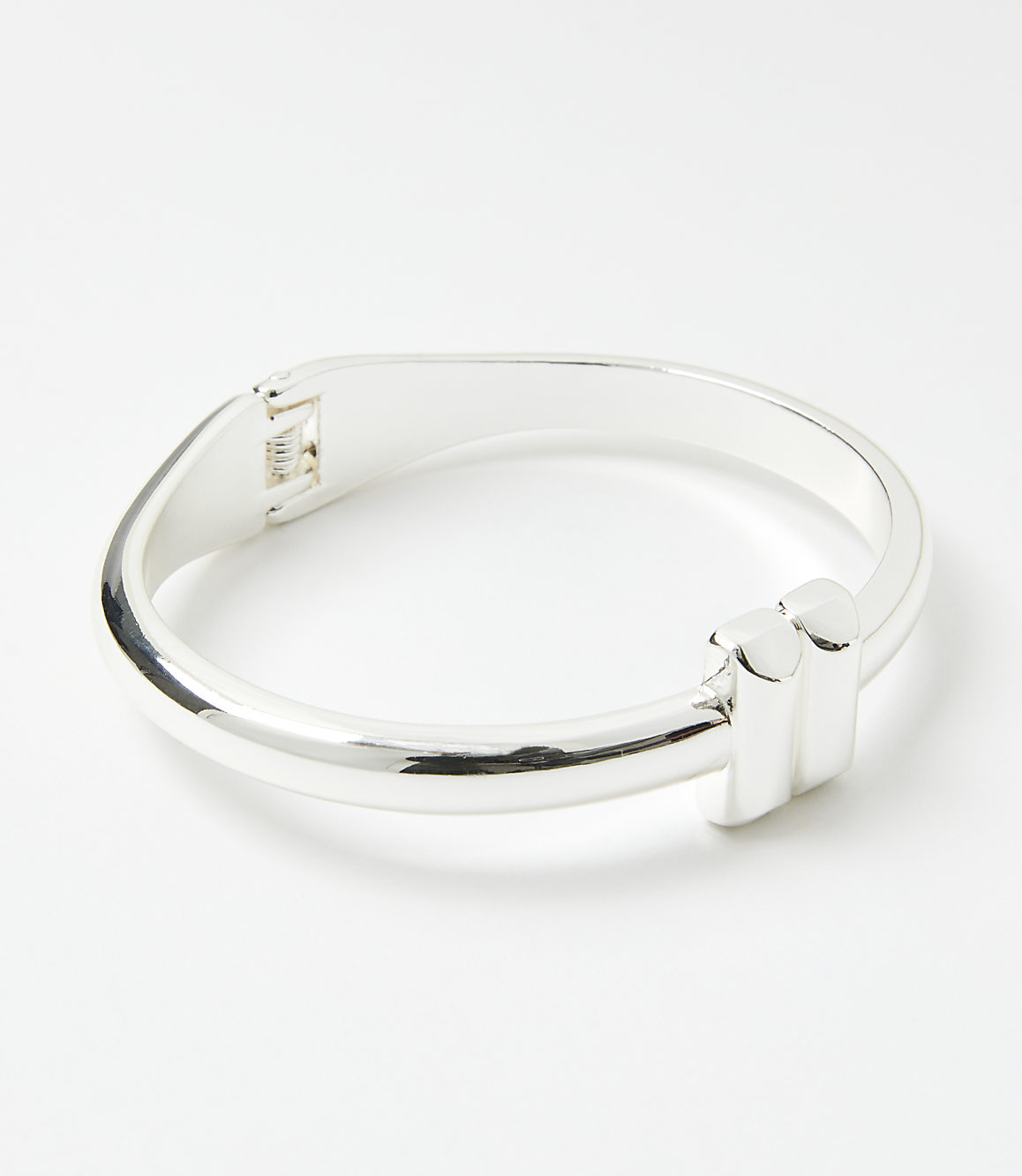 A silver bracelet with a modern design sits on a plain white background.