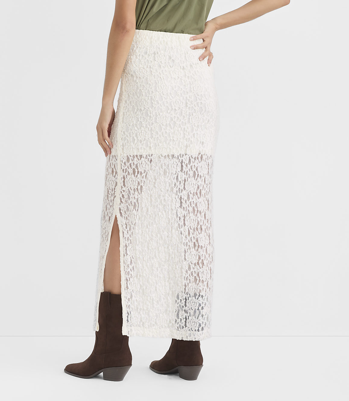 A person in a white lace skirt and brown boots stands against a plain white background.