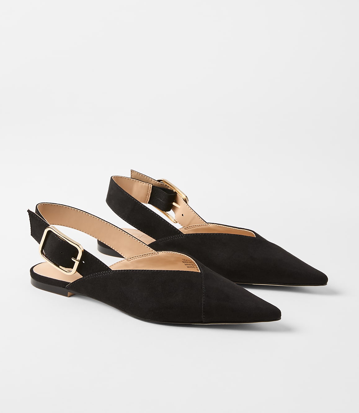 A pair of black suede slingback flats with pointed toes and gold buckles rests on a plain white background.