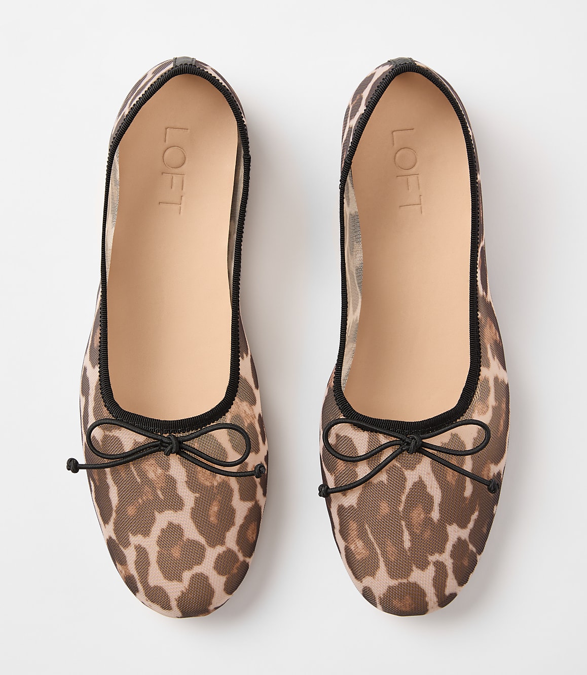 A pair of leopard-print mesh ballet flats with black bows are laid flat against a plain white background.