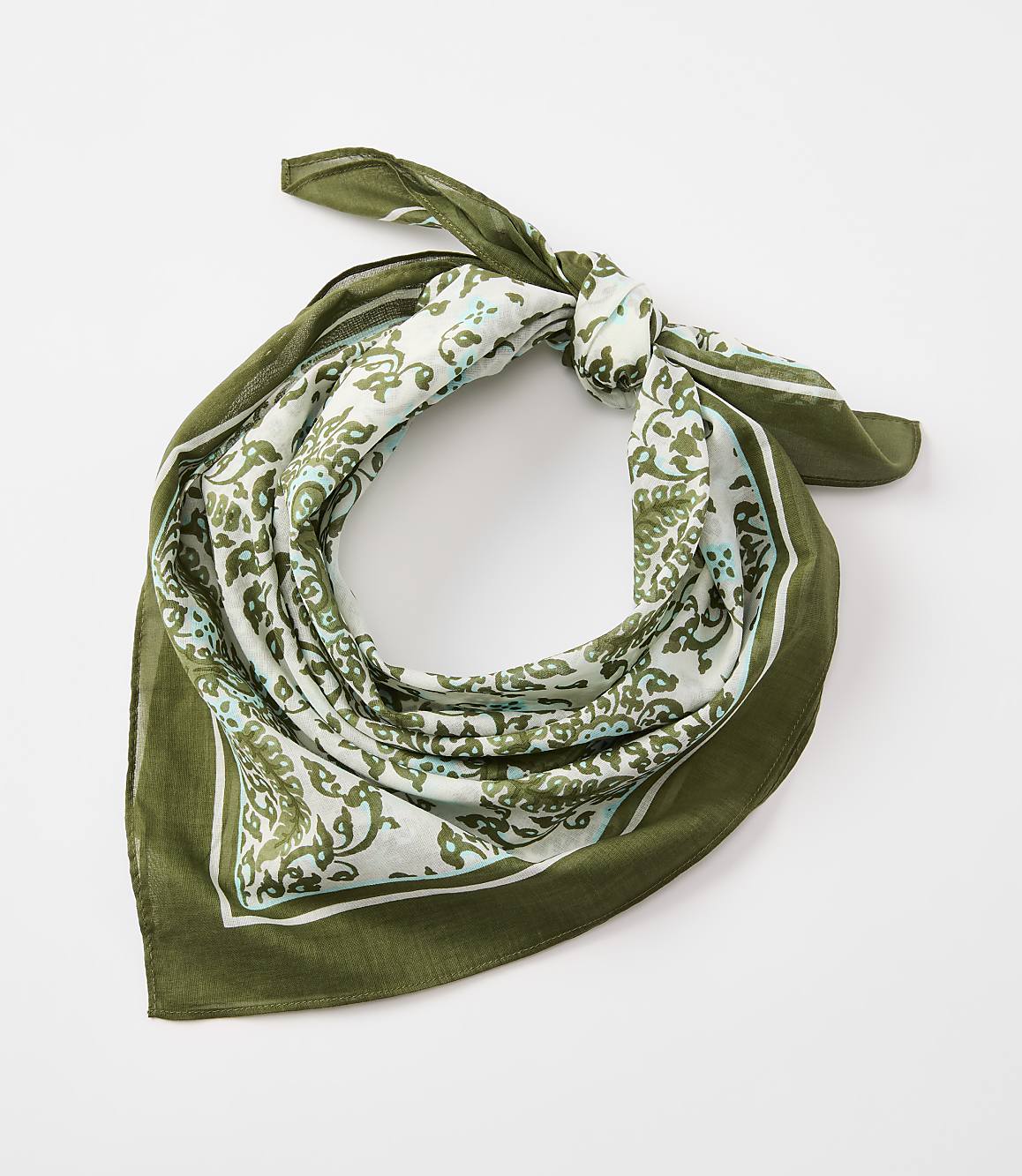 A green bandana with a white and green paisley pattern is tied in a knot against a plain white background.
