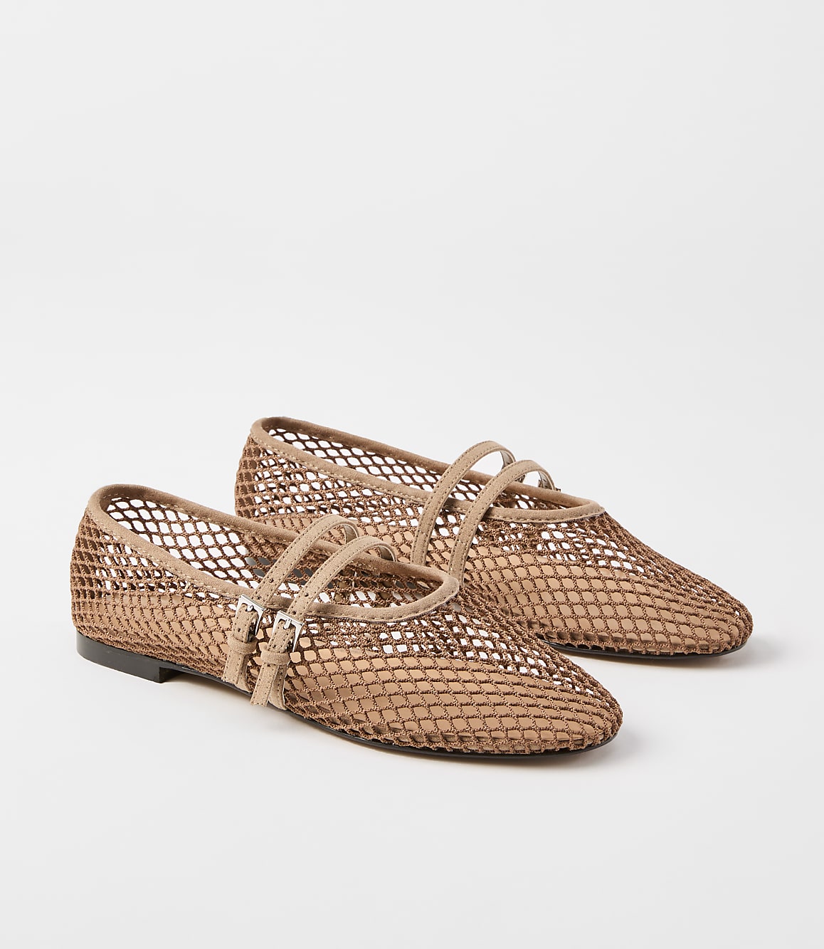 A pair of tan mesh ballet flats with double straps and buckle closures rests on a plain white background.