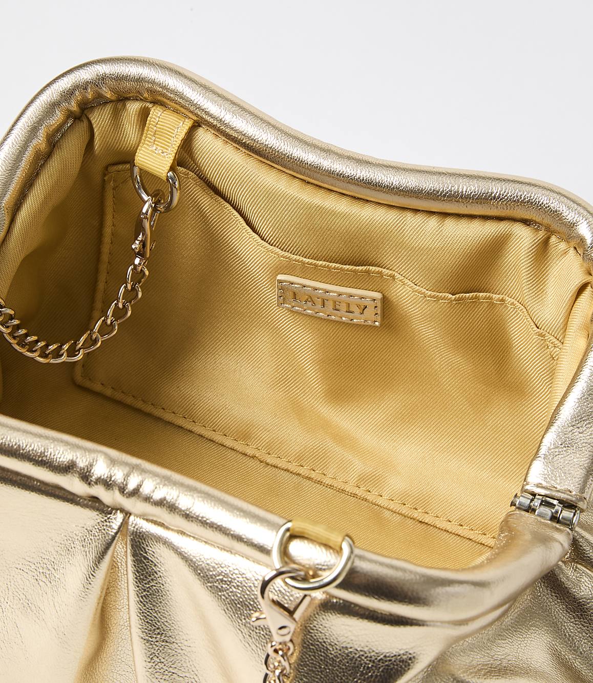 A metallic gold clutch with a chain strap is open against a plain white background.