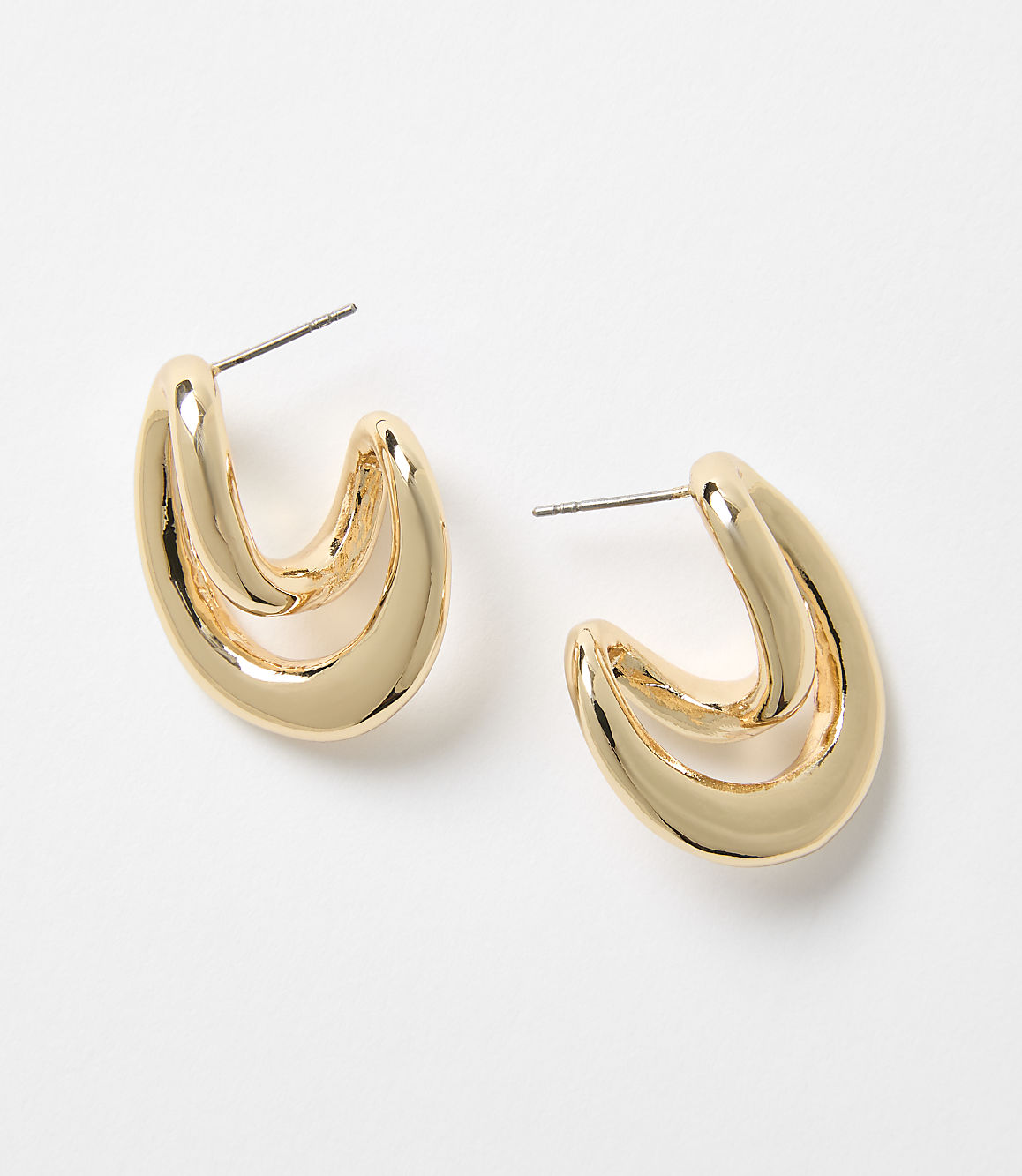 A pair of shiny gold hoop earrings with a double-loop design rests on a plain white background.