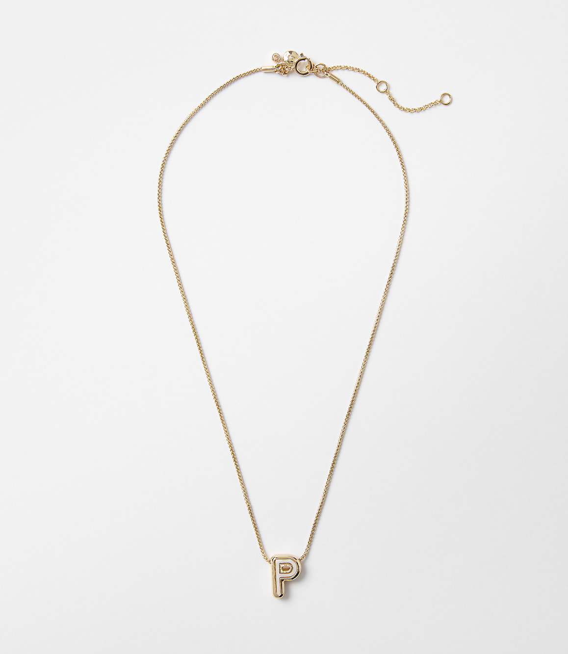 A delicate gold necklace with a letter "P" pendant hangs against a plain white background.