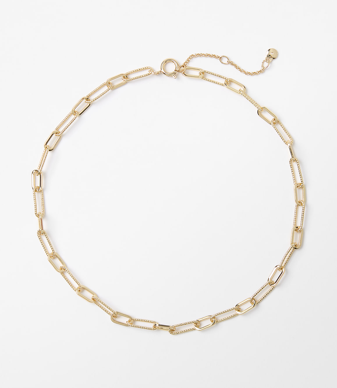 A delicate gold chain necklace with elongated oval links rests on a plain white background.