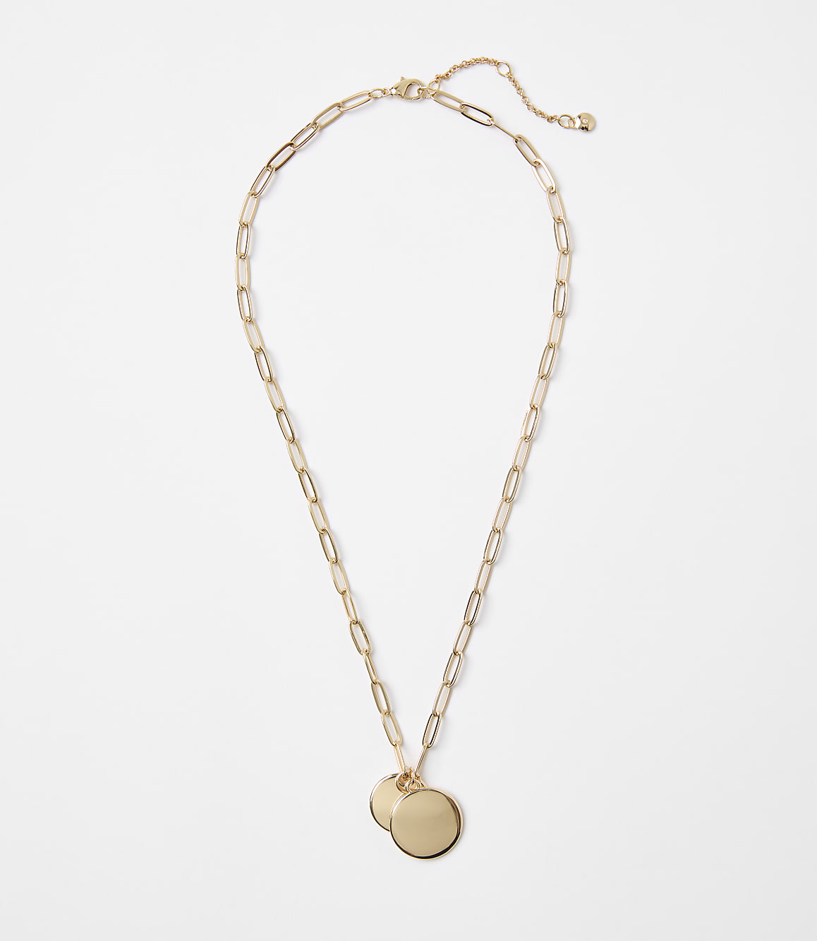 A gold necklace with two circular pendants rests on a plain white background.