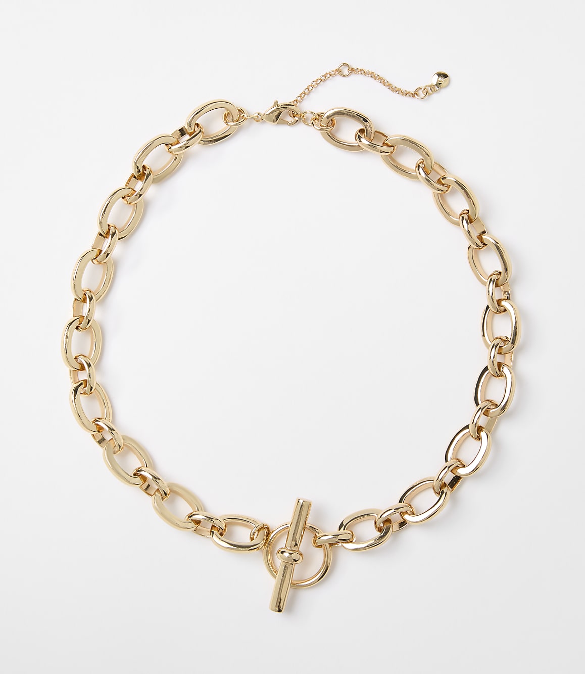 A gold chain necklace with a toggle clasp lies on a plain white background.
