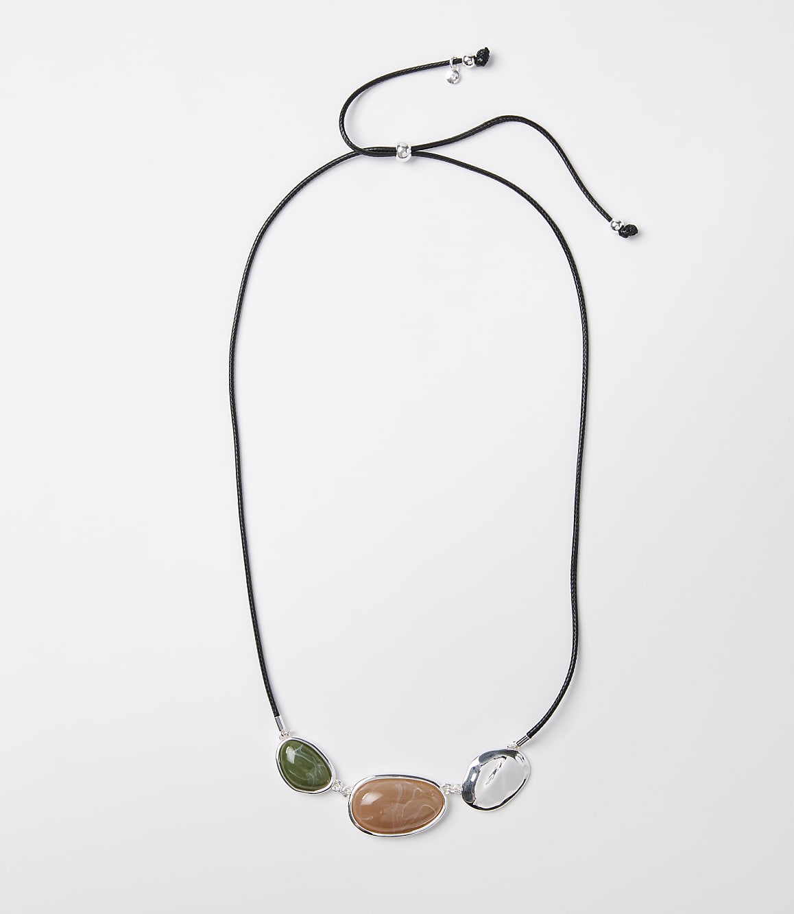 A black cord necklace with three polished stones&mdash;green, peach, and white&mdash;is laid out against a plain white background.