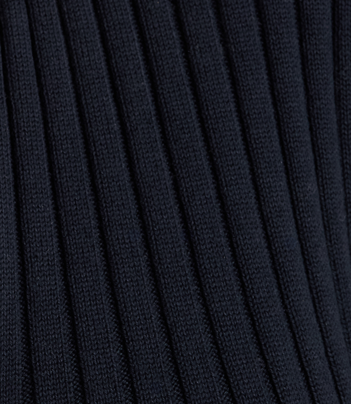 Dark navy ribbed fabric fills the frame, with the texture of the knit creating a sense of depth.