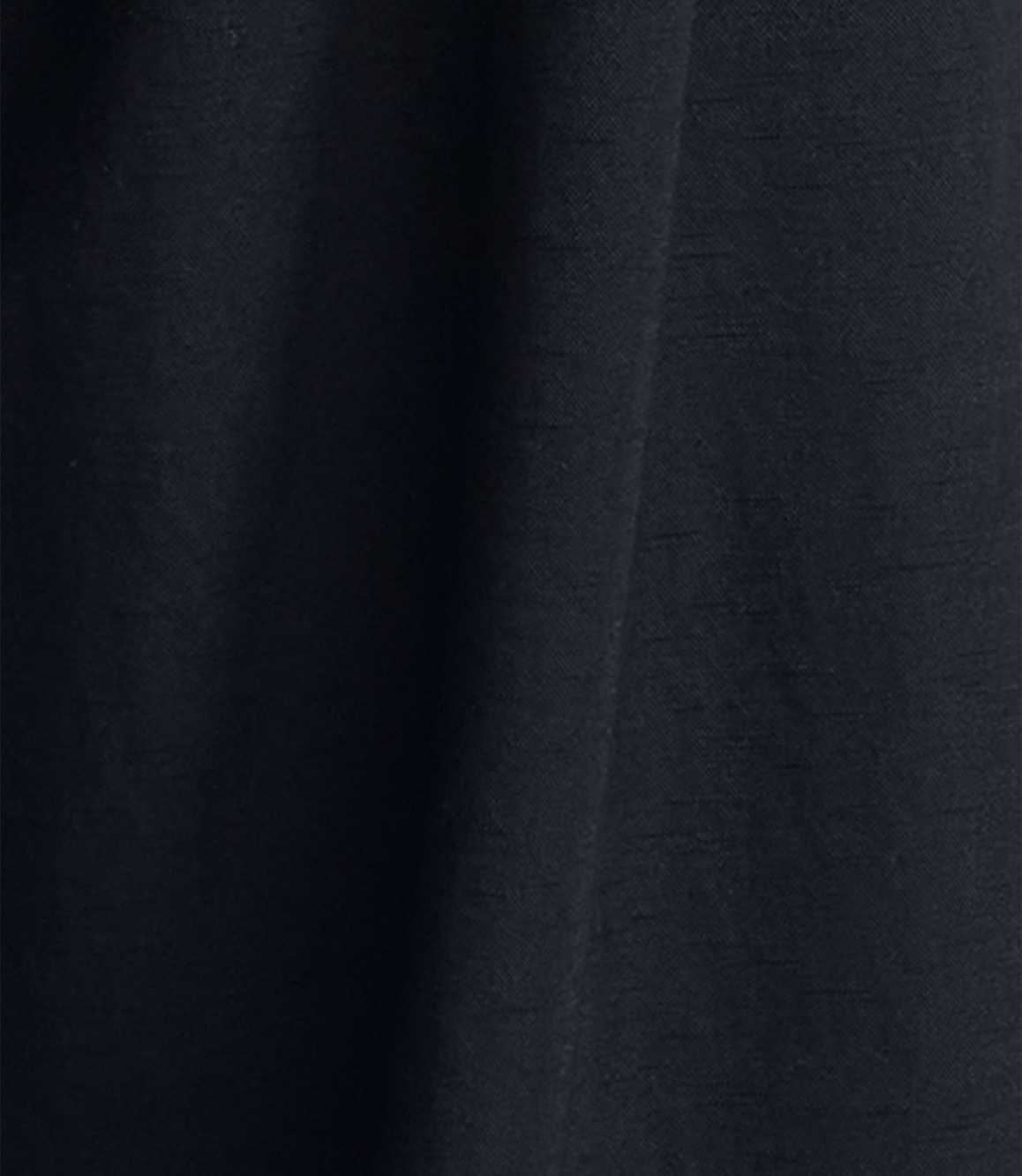 Dark, textured fabric folds in the foreground against a similarly dark, indistinct background.
