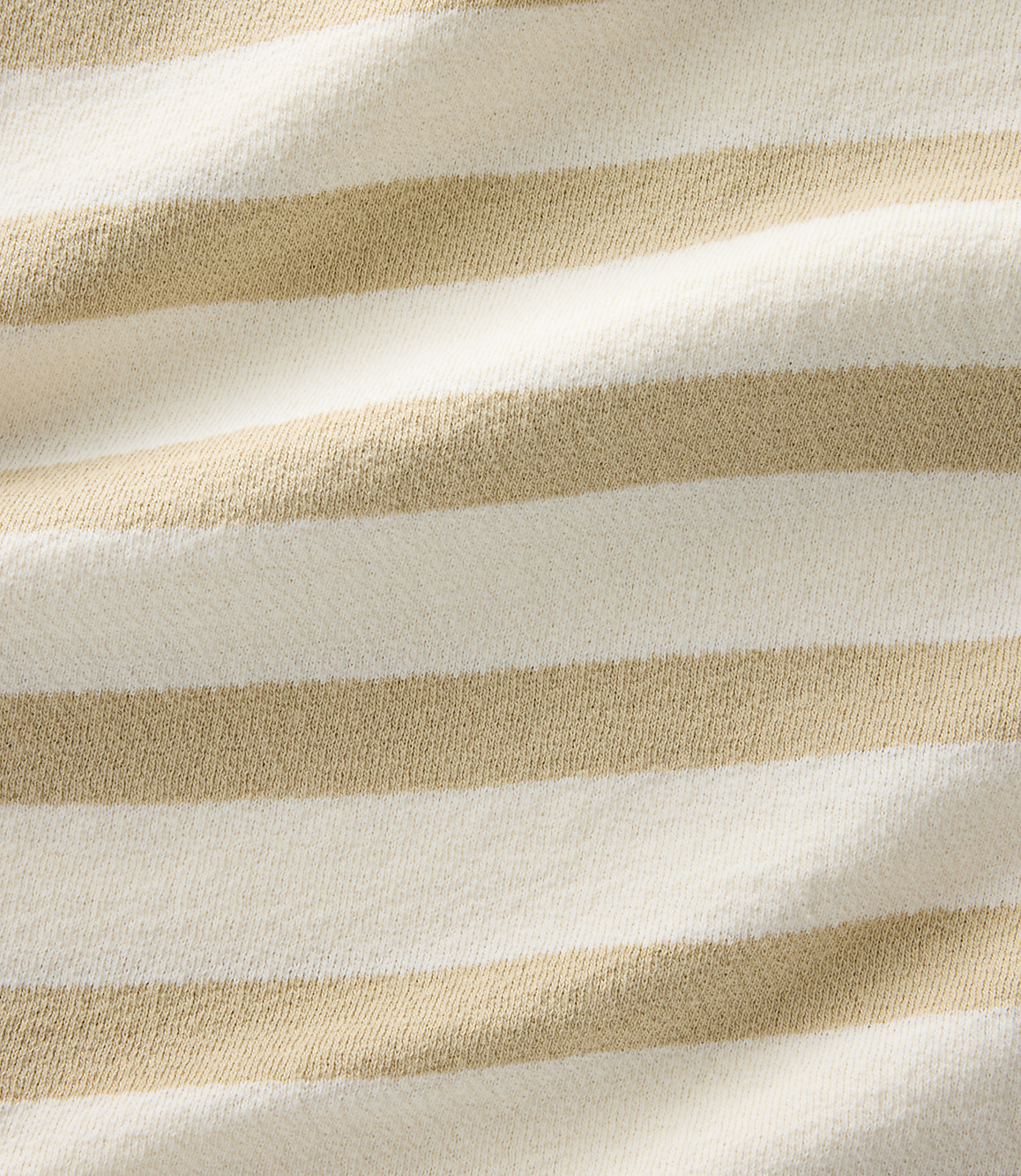 A close-up view of a beige and white striped fabric fills the frame, with the texture of the knit visible throughout.