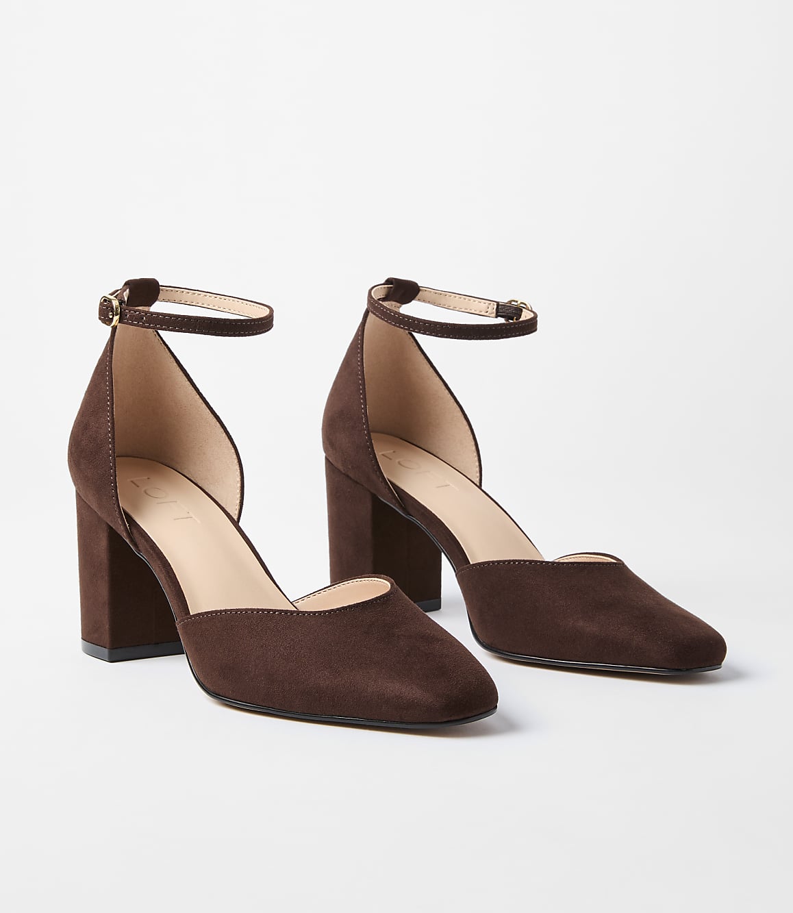 A pair of brown suede ankle strap heels rests on a plain white background.
