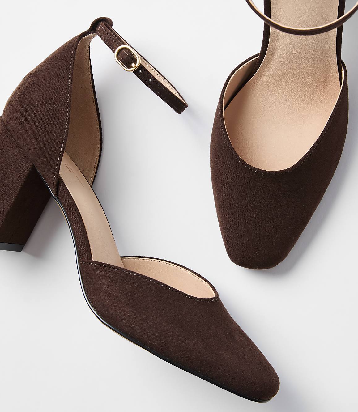 A pair of brown suede block heels with ankle straps are displayed against a plain white background.
