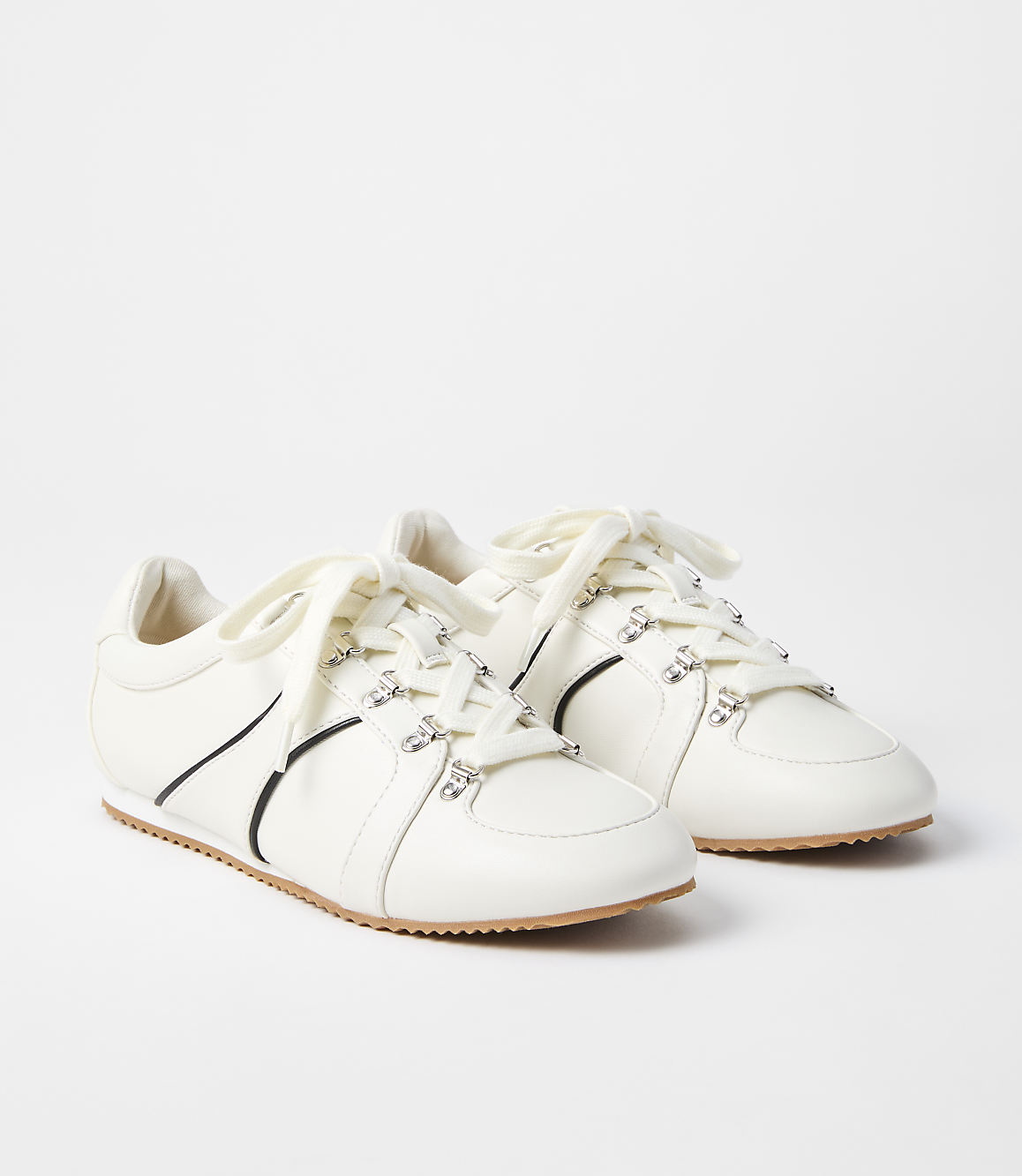 A pair of white leather sneakers with crystal embellishments and black accents are displayed against a plain white background.