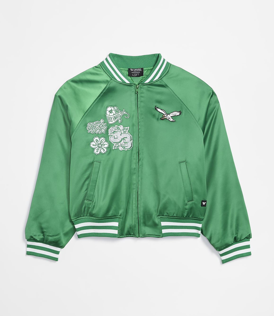 A green satin bomber jacket with embroidered patches of a bird and flowers is displayed against a plain white background.