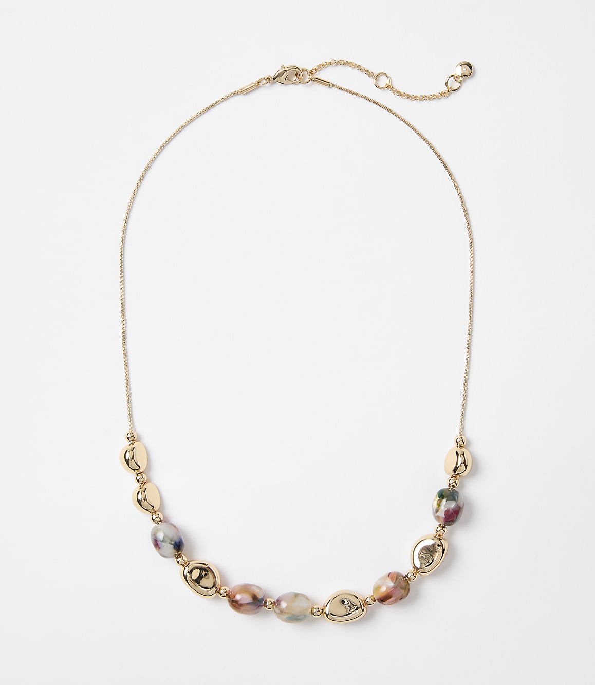 A delicate gold chain necklace with oval-shaped beads in earthy tones and gold accents rests on a plain white background.