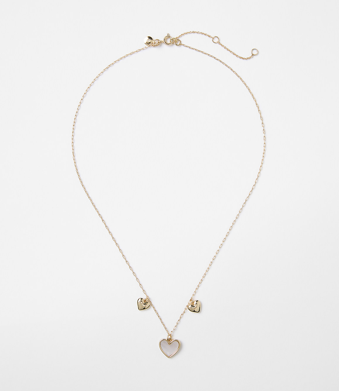 A delicate rose gold necklace with a heart-shaped pendant and two smaller heart charms hangs against a plain white background.