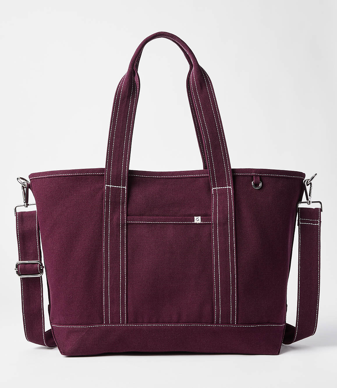 A maroon canvas tote bag with white stitching and a detachable shoulder strap sits against a plain white background.