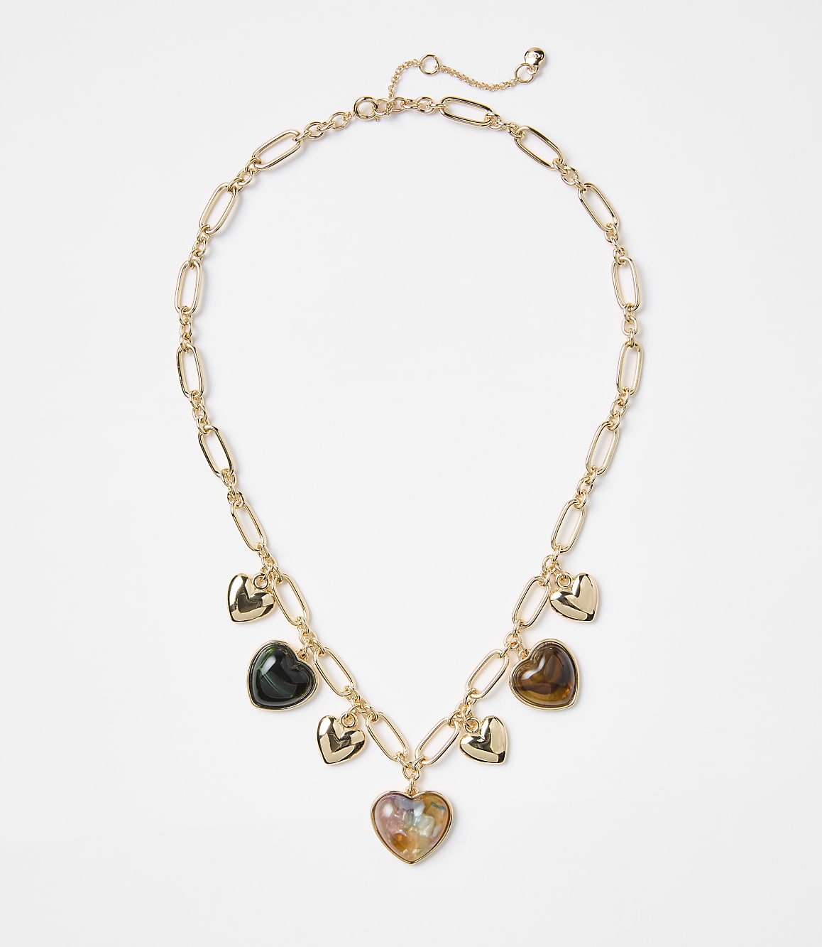 A gold chain necklace with multiple heart-shaped charms, some metallic and others iridescent, rests against a plain white background.