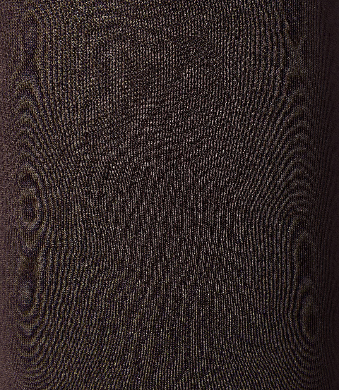 A close-up of dark brown ribbed fabric fills the frame, with subtle variations in light and shadow creating depth.