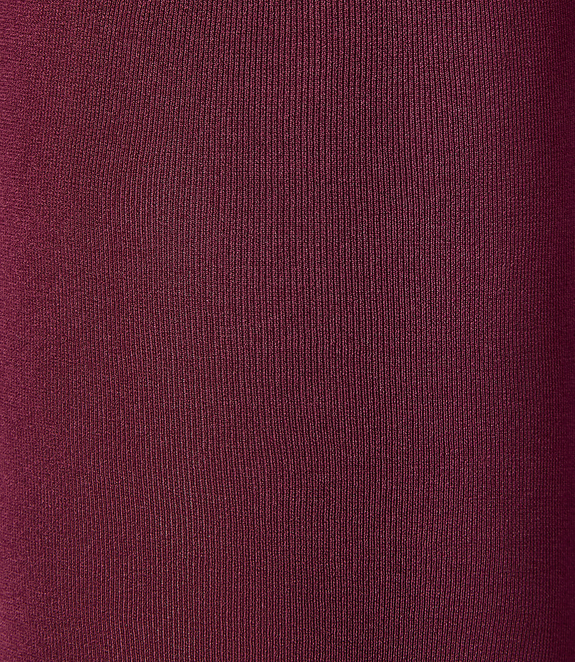 A close-up of a textured, deep red fabric fills the frame, with subtle vertical ribbing creating a sense of depth.