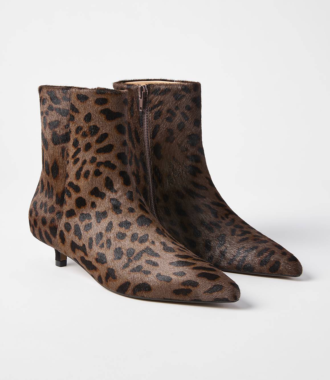 A pair of leopard-print calf-hair ankle boots with pointed toes and kitten heels are displayed against a plain white background.