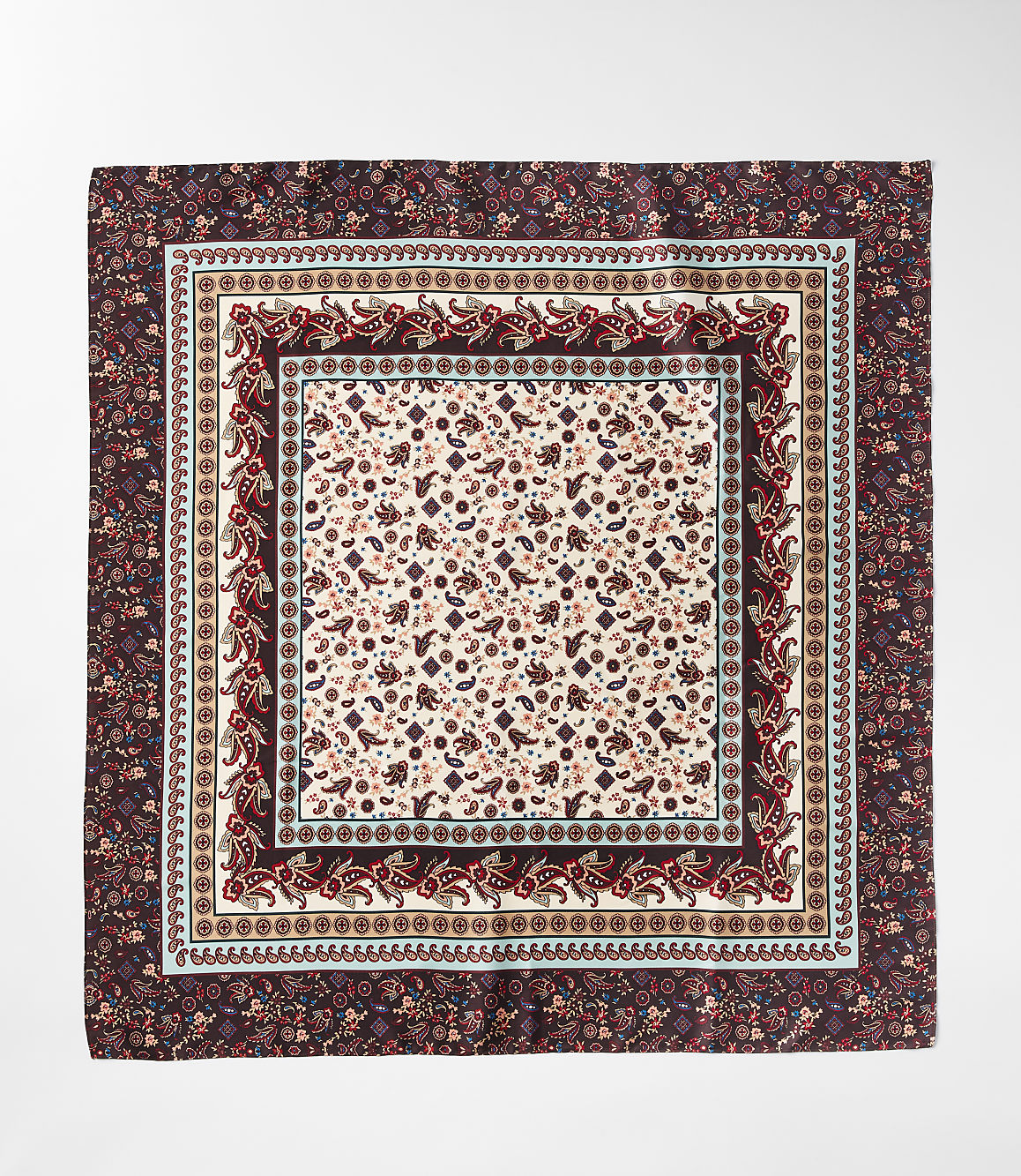 A square silk scarf with intricate paisley and floral patterns in shades of burgundy and cream is laid flat against a white background.