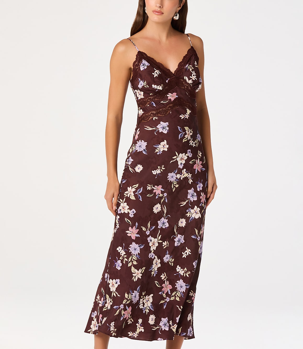 A woman in a floral slip dress stands against a plain white background.