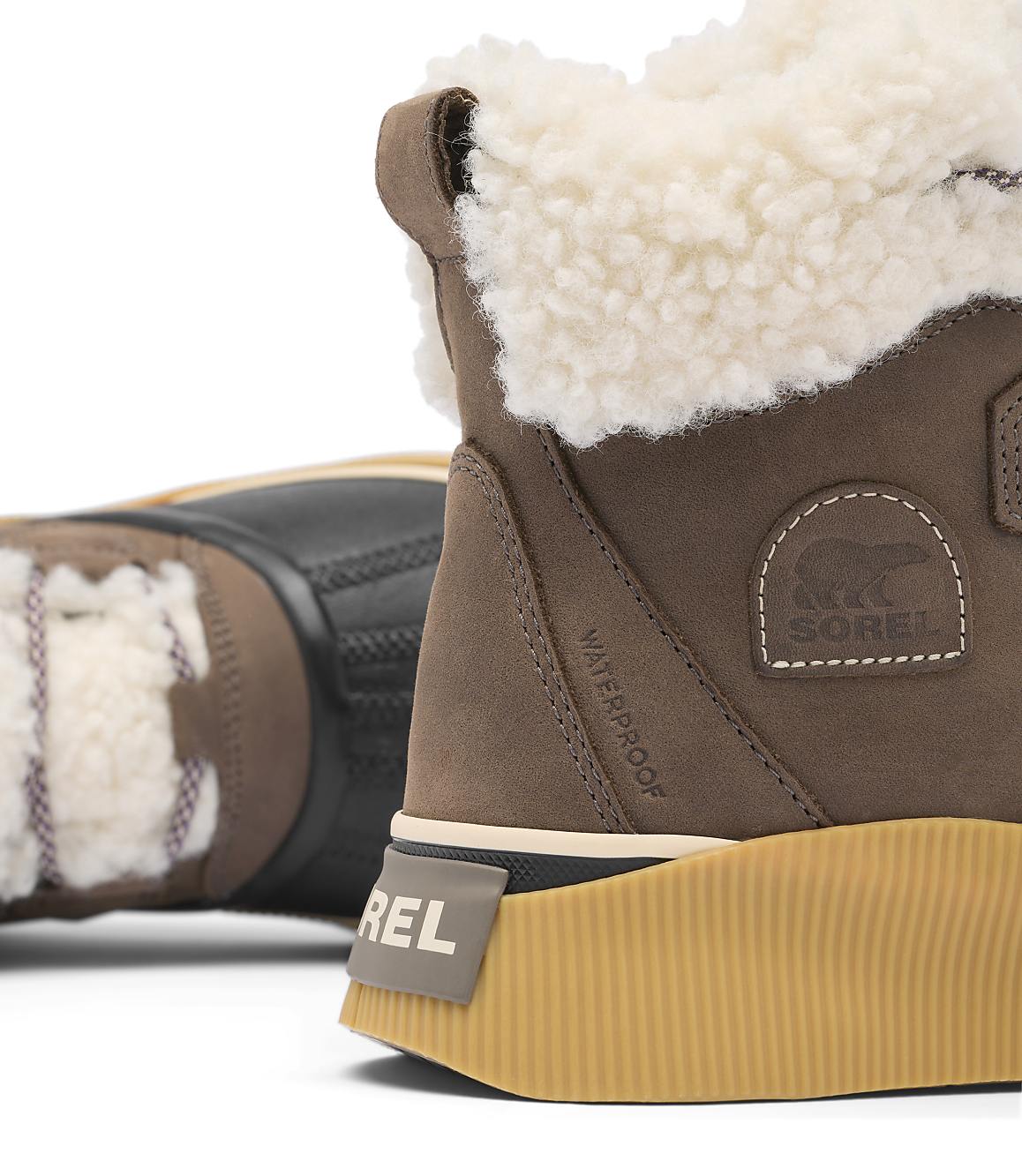A close-up of a brown Sorel boot with a fluffy white lining is in the foreground, while another boot is blurred in the background.