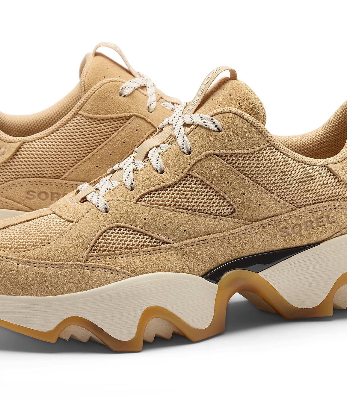 A pair of tan suede and mesh Sorel sneakers with chunky cream and tan soles are displayed against a plain white background.