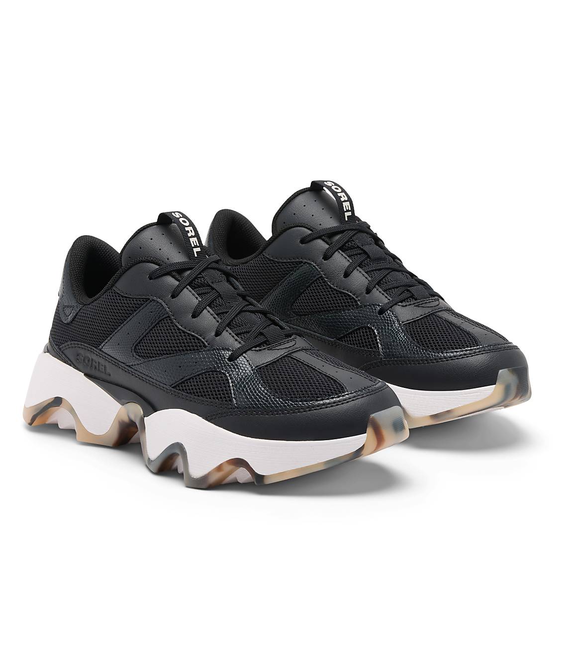 A pair of black Sorel sneakers with chunky white soles and translucent, patterned outsoles rest on a plain white background.