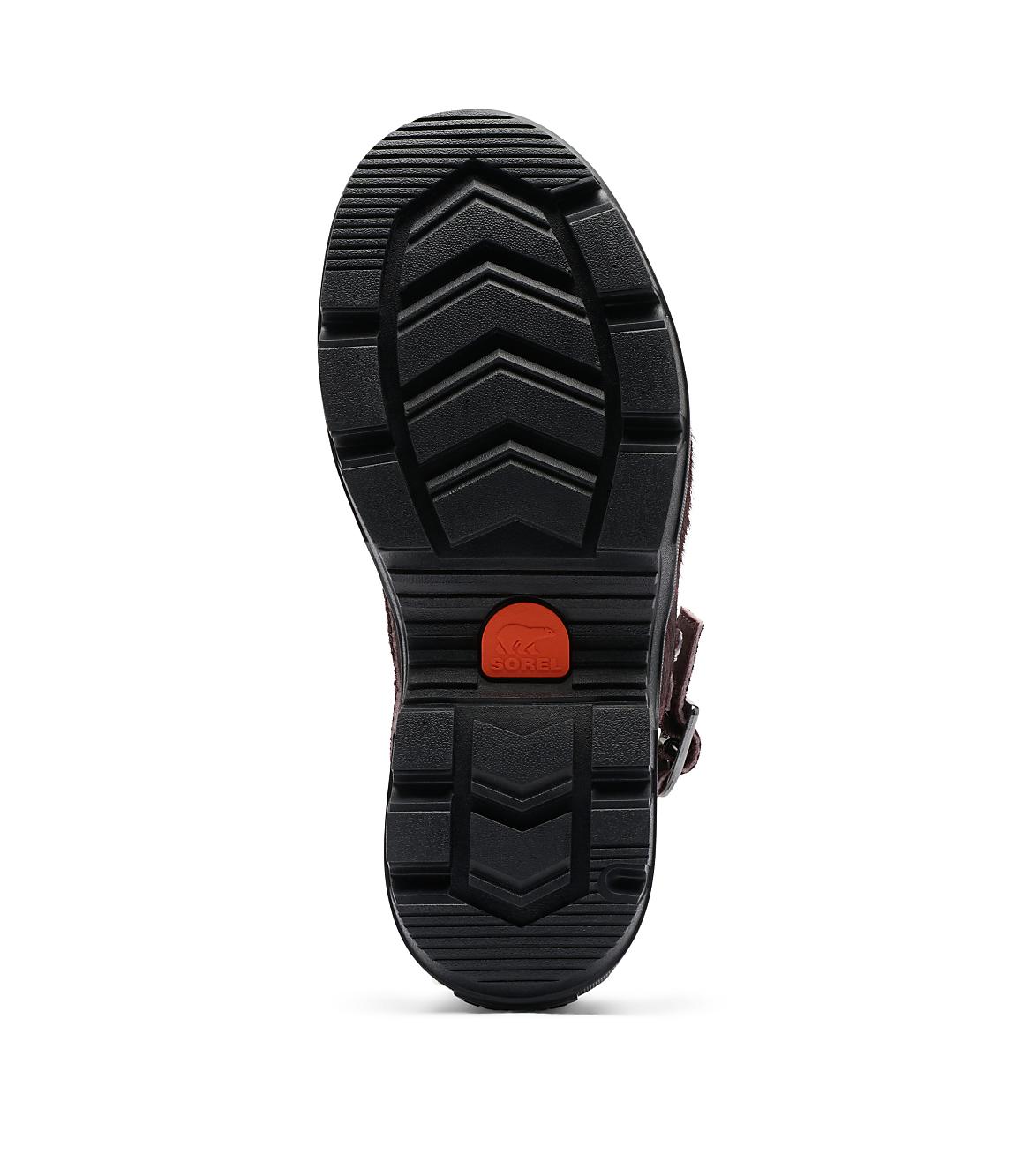 A black lug sole boot with a red accent is shown against a plain white background.