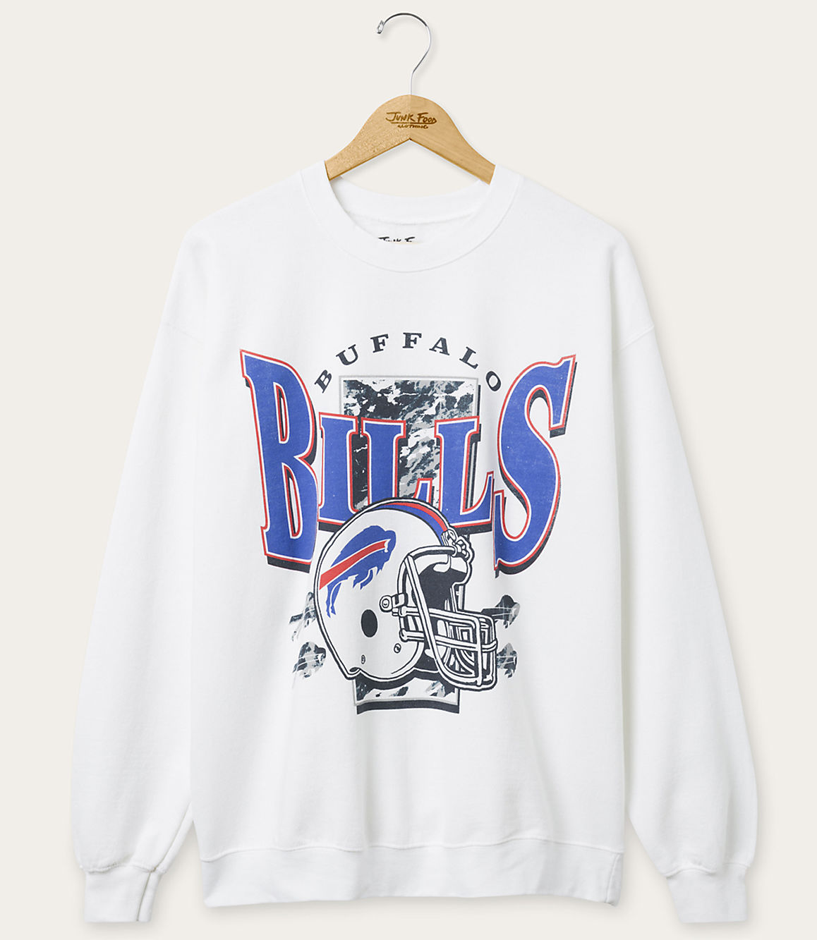 A white Buffalo Bills sweatshirt with a graphic of a helmet and team name hangs on a wooden hanger against a plain background.
