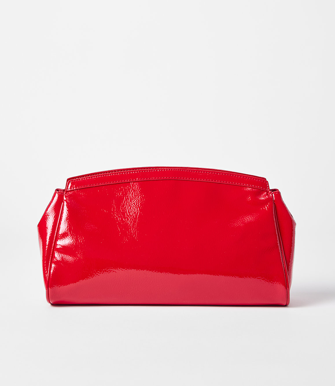 A shiny red clutch rests on a white surface against a plain white background.