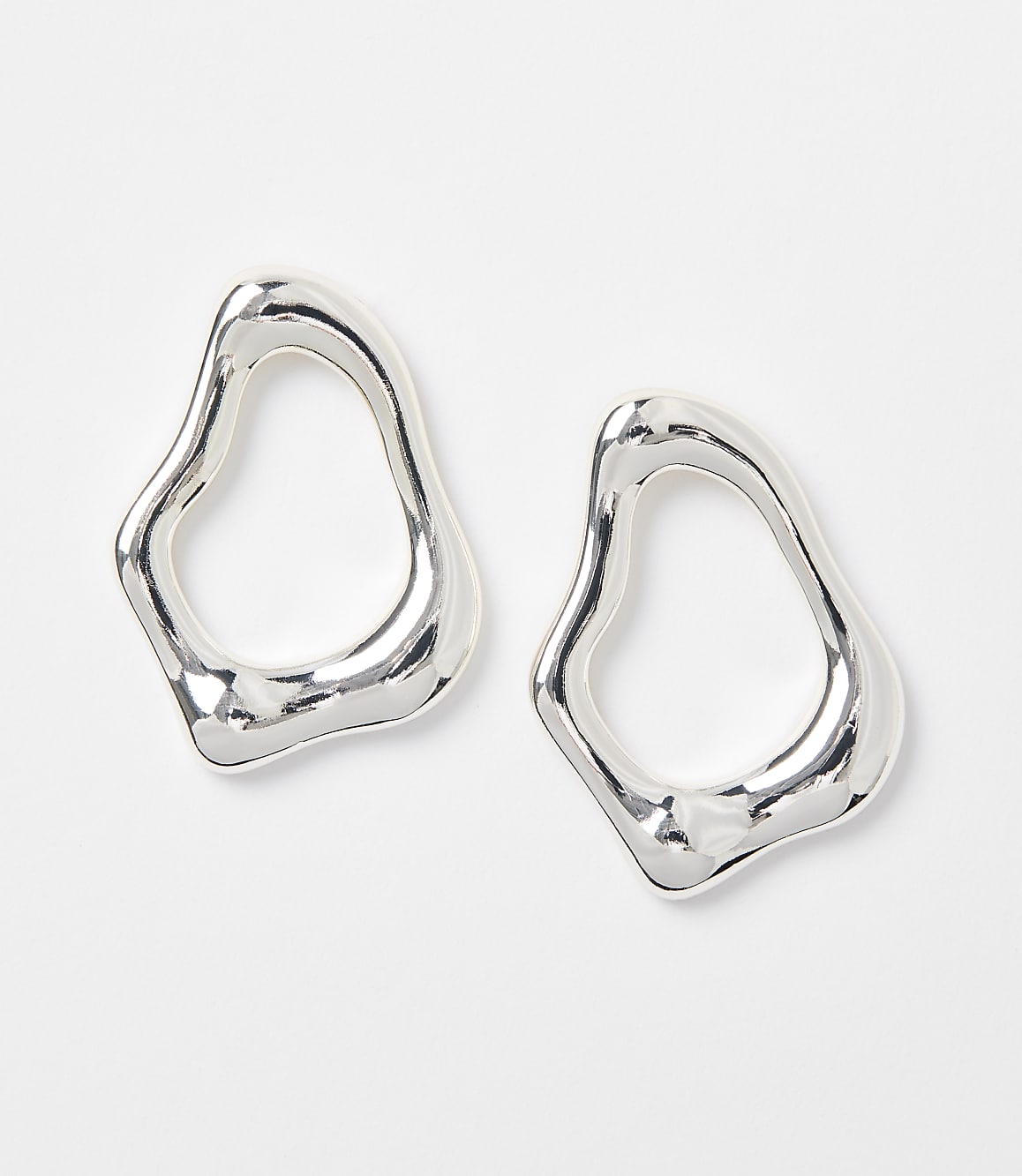 Two abstract, silver-toned earrings with organic shapes rest on a plain white background.