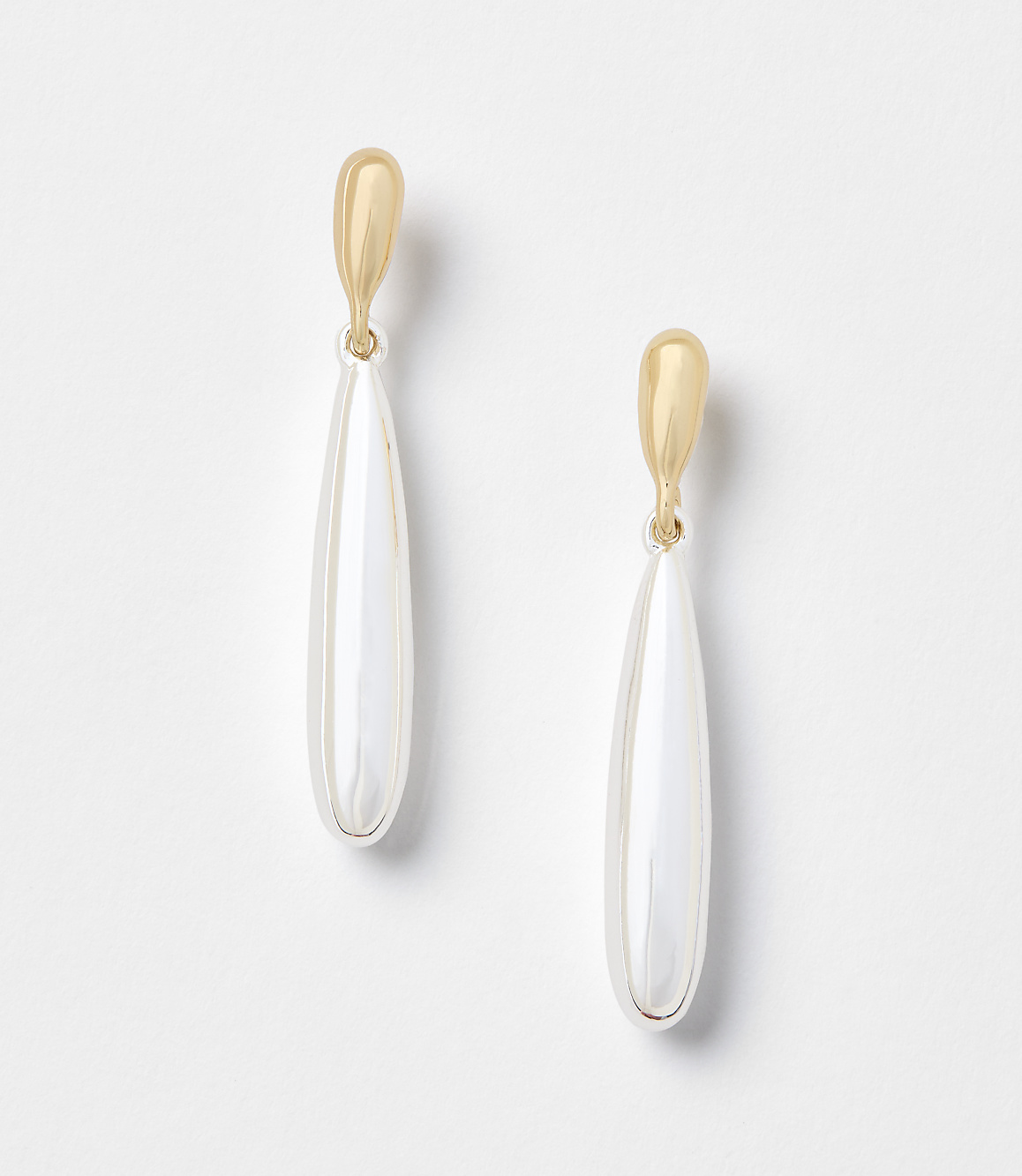 A pair of gold and pearl drop earrings hang against a plain white background.