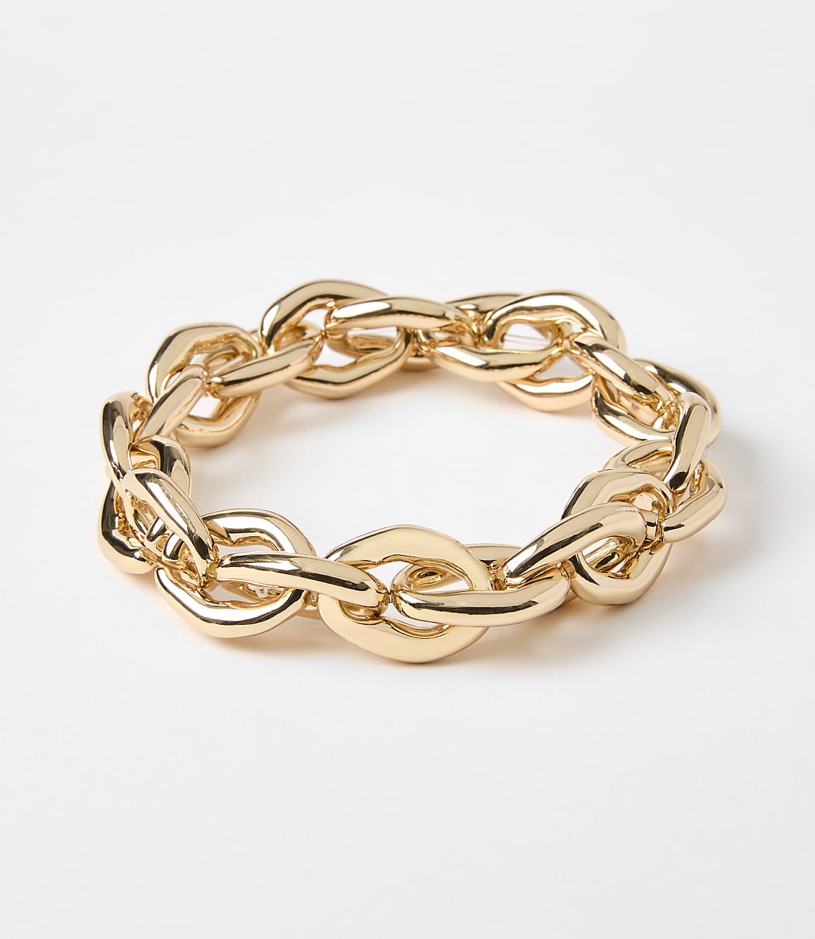 A thick, gold chain bracelet lies on a plain white background.