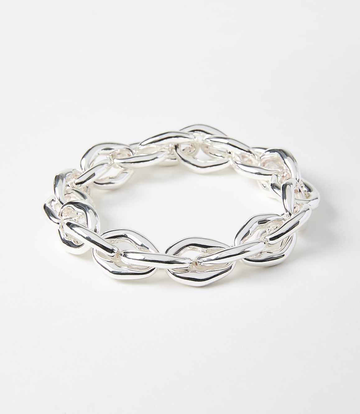 A chunky silver chain bracelet lies on a plain white background.