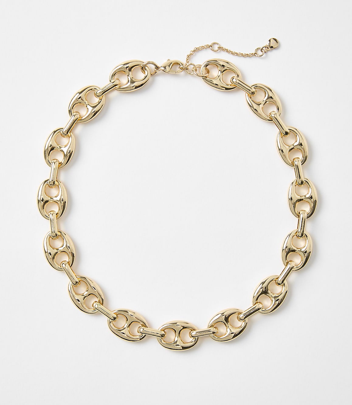 A gold chain necklace with oval links rests on a plain white background.