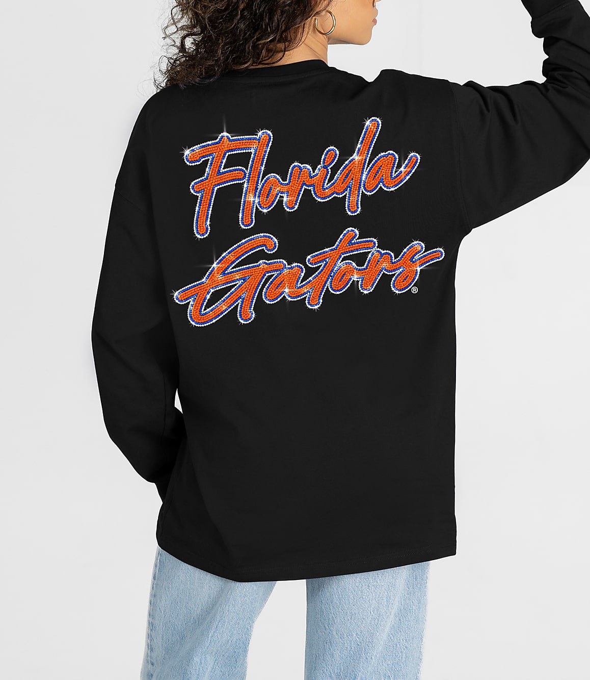 A person in a black long-sleeved shirt with "Florida Gators" written on the back stands against a plain white background.