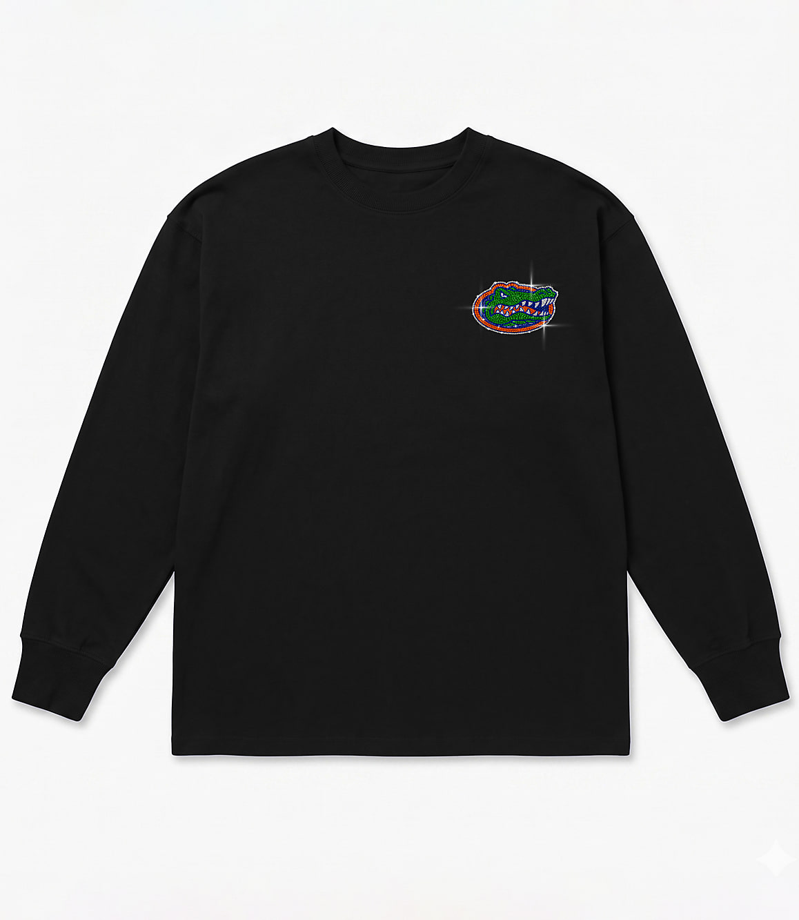 A black long-sleeved t-shirt with a glittery alligator logo on the left chest is laid flat against a white background.