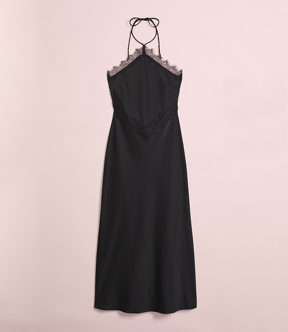 A black satin slip dress with lace trim hangs against a soft pink background.