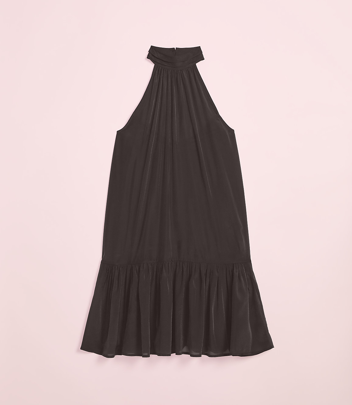 A dark, flowing halter dress with a ruffled hem rests on a soft pink background.