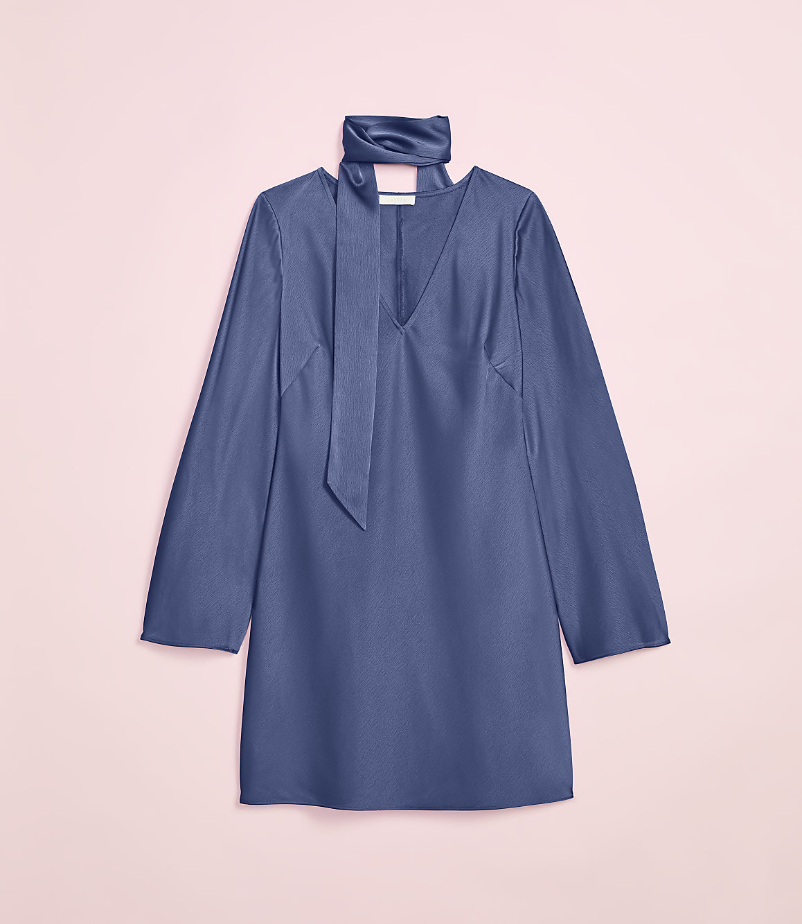 A blue satin dress with a tie neck is laid flat against a soft pink background.